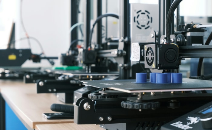 3D printers creating blue objects in a modern printing lab
