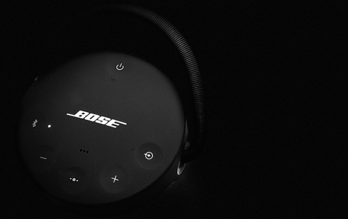 A black Bose speaker with illuminated controls in the dark