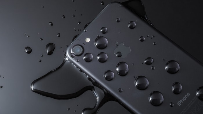A black iPhone 7 with drops of water