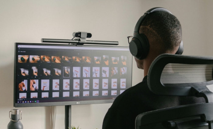 A person editing a gallery of images on a computer monitor