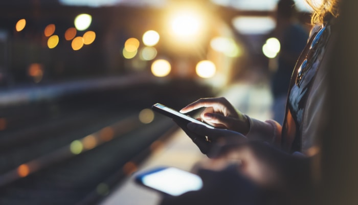 A person using a smartphone at a train station