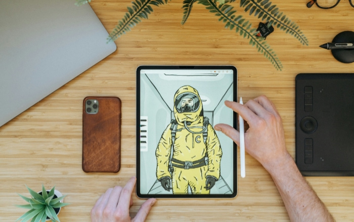 A tablet displaying a digital drawing of an astronaut in a yellow suit