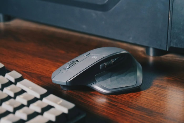 A wireless computer mouse placed on a wooden desk