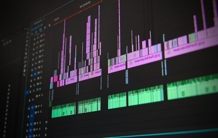 Adobe Premiere Pro timeline interface with colorful audio and video tracks