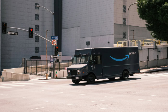 Amazon Prime delivery van driving on city street resized
