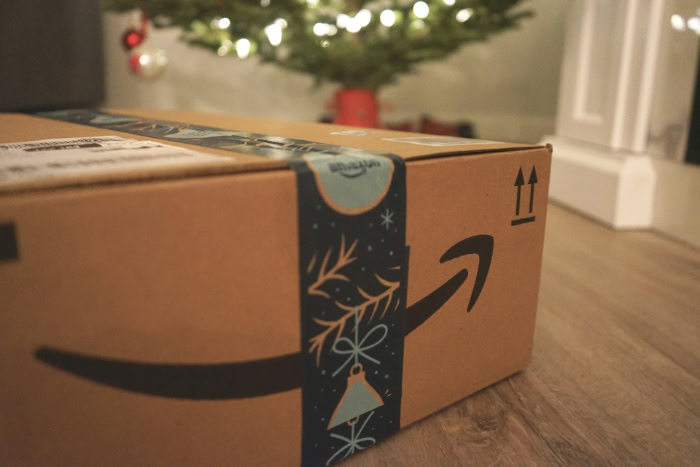 Amazon holiday shipping box near a Christmas tree resized