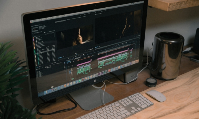 An editing workstation with Adobe Premiere Pro open on a desktop computer