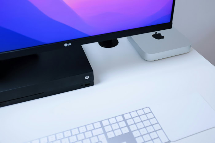 Apple Mac mini and Xbox console on white desk