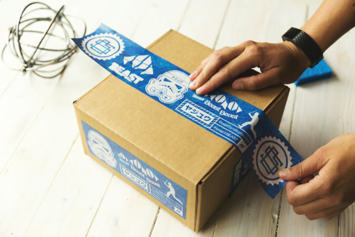 Applying blue custom printed tape to shipping