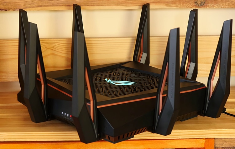 Black Asus RoG Rapture GT-AX11000 on wooden surface