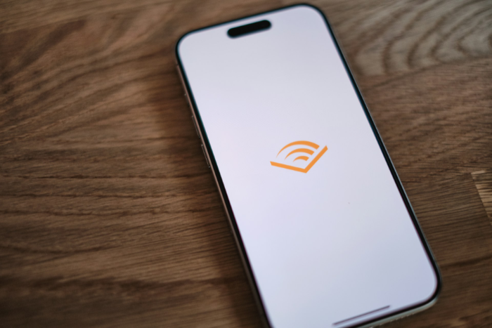 Audible app logo on iPhone screen on wooden table