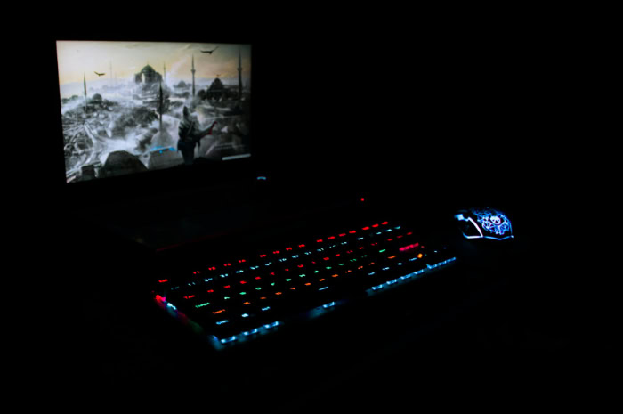 Backlit gaming keyboard mouse and screen at night