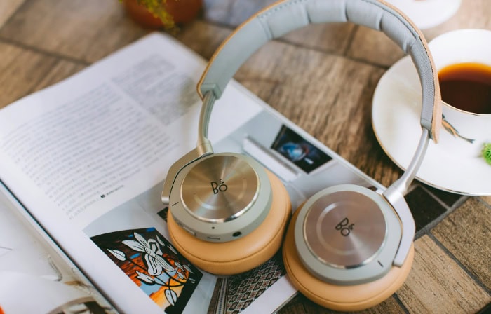 Bang and Olufsen headphones on magazine with coffee cup nearby