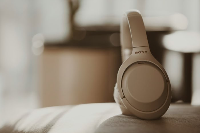 Beige Sony over ear noise cancelling headphones on a soft surface