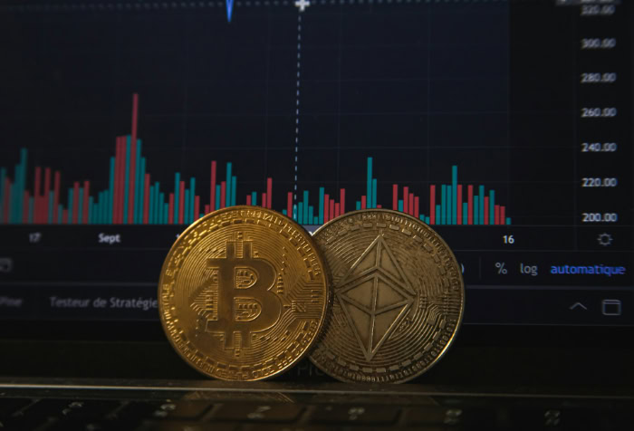 Bitcoin and Ethereum coins in front of trading chart