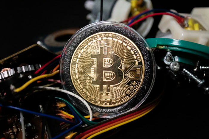 Bitcoin coin surrounded by electronic wires