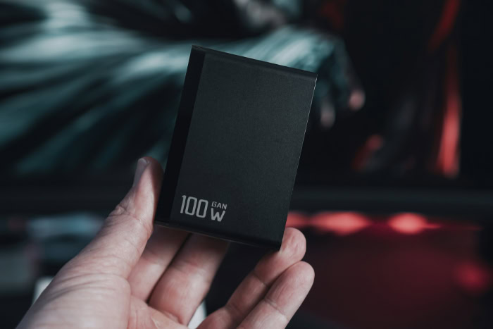 Black 100W GaN charger compact design held in hand