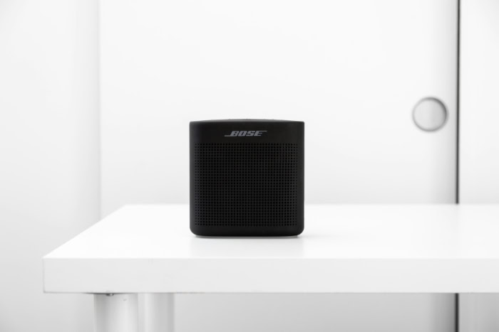 Black Bose portable Bluetooth speaker on white desk