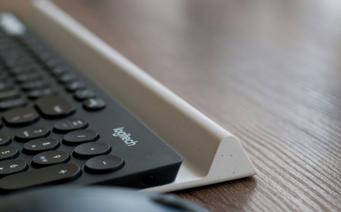 Black Logitech wireless keyboard on a wooden desk