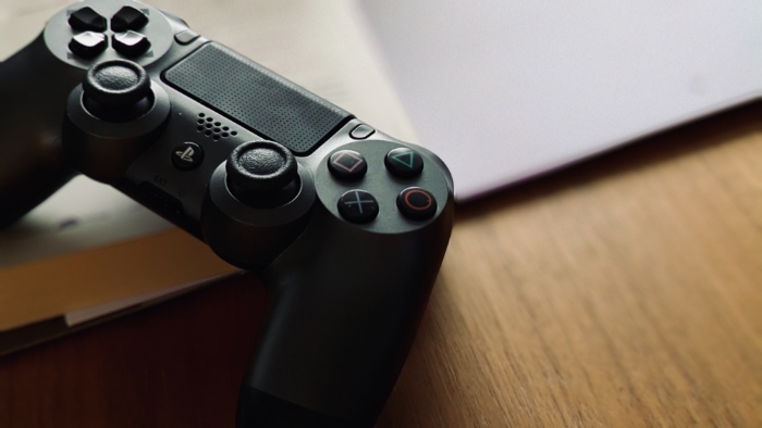 Black PS4 Controller on wooden desk