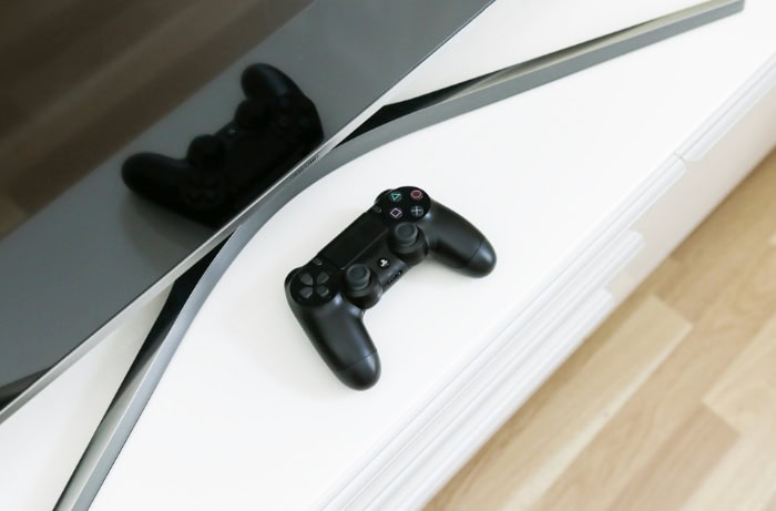 Black PlayStation controller placed on a table