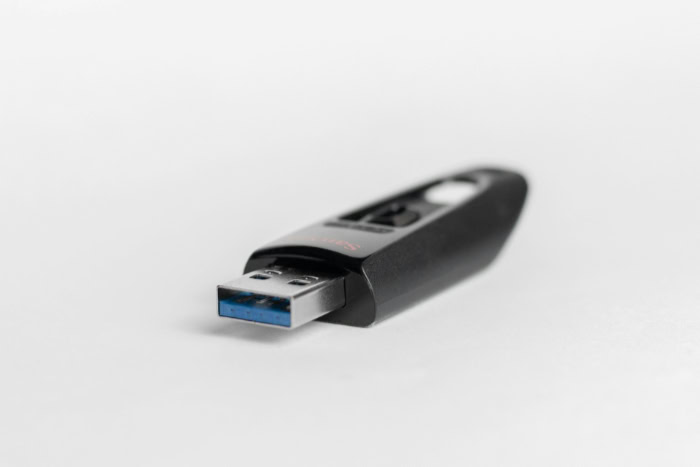 Black SanDisk USB flash drive on white background