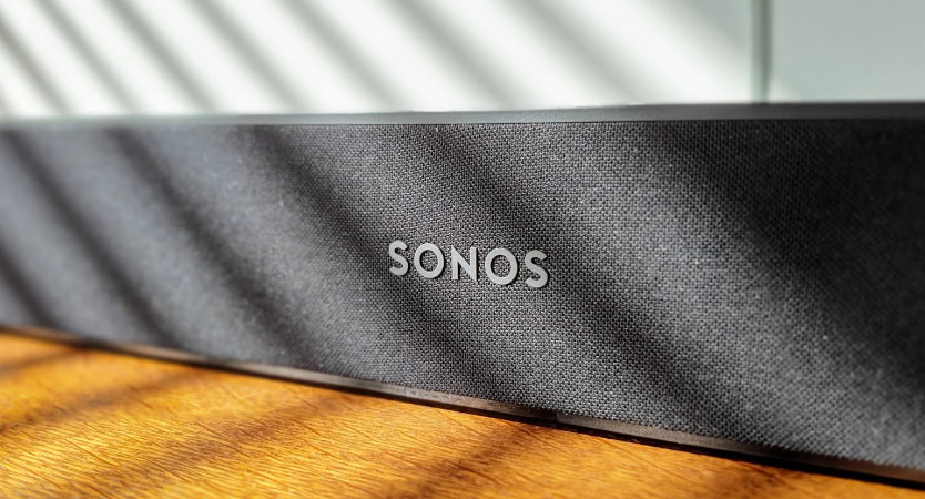Black Sonos fabric soundbar on wooden surface