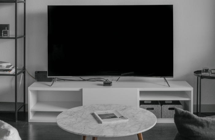 Black TV on white desk