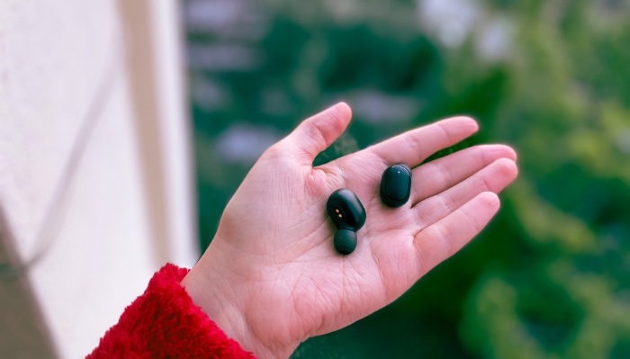 Black earbuds on hand