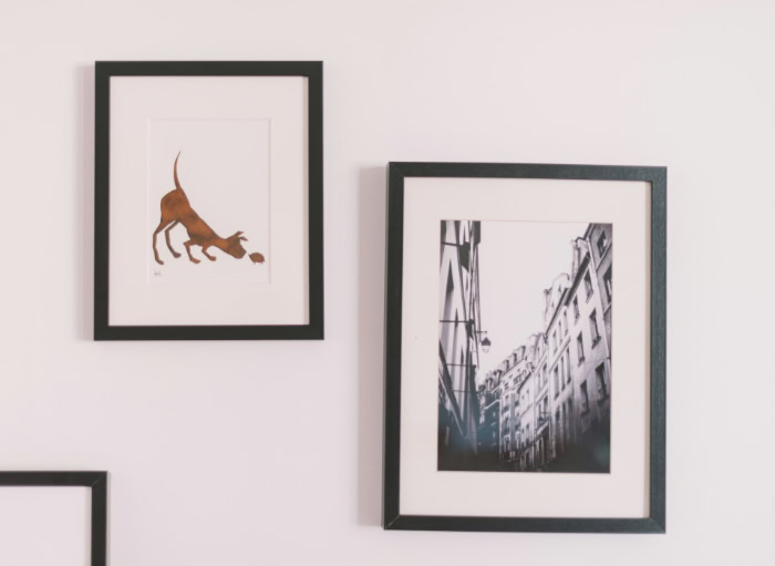 Black framed prints hanging on a white wall