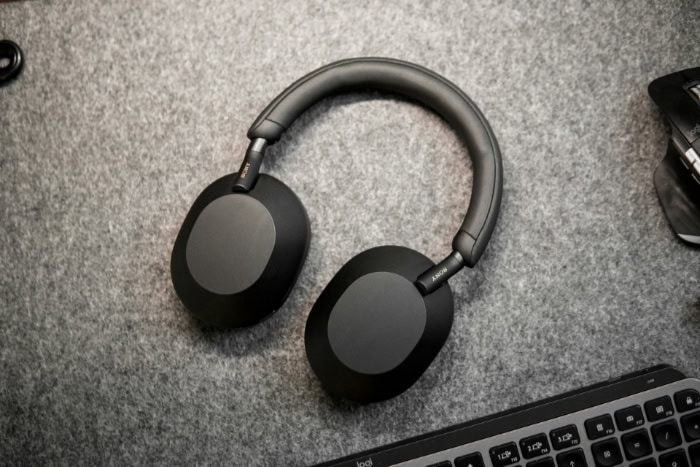 Black over ear headphones on a desk with a keyboard