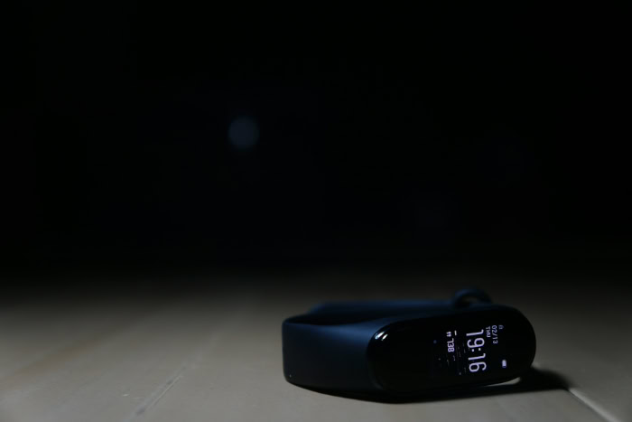Black smart fitness tracker lying on dark surface