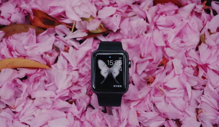 Black smartwatch on purple flowers