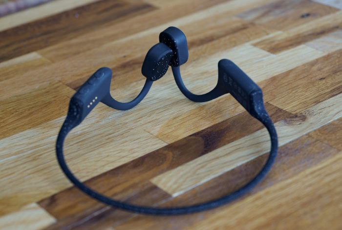 Black speckled bone conduction headphones on wooden table