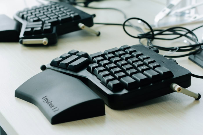 Black split ergonomic mechanical keyboard on a desk