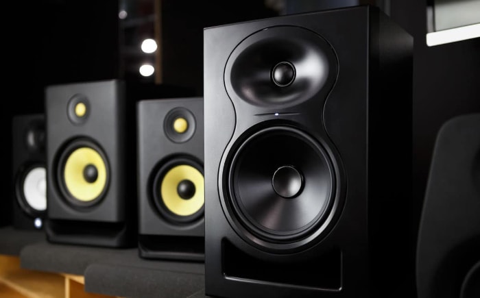 Black studio monitor speakers with yellow woofers