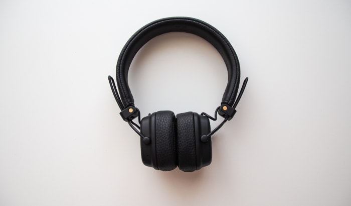 Black wireless headphones on white surface