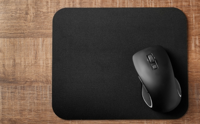 Black wireless mouse on dark mouse pad