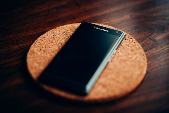 BlackBerry smartphone on cork coaster wooden table surface