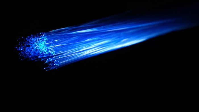Blue fiber optic strands fanned out showing light transmission