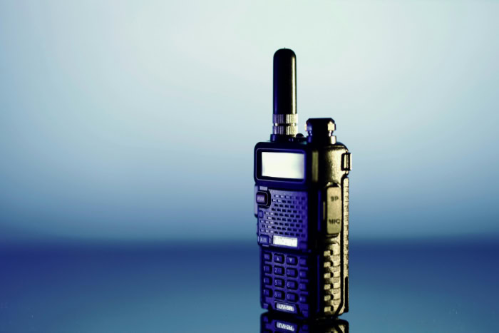 Blue two way radio walkie talkie on reflective surface