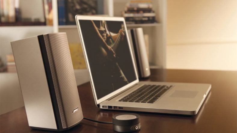 Silver Bose Companion 20 near Macbook on wooden table