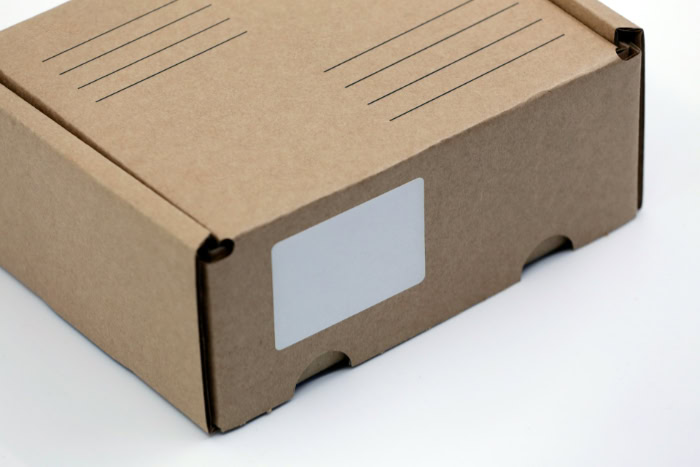 Brown cardboard shipping box with blank white label