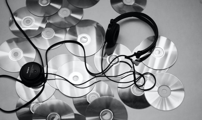CDs near black headphone