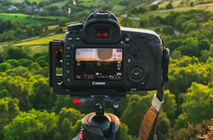 Canon DSLR camera set on tripod overlooking landscape
