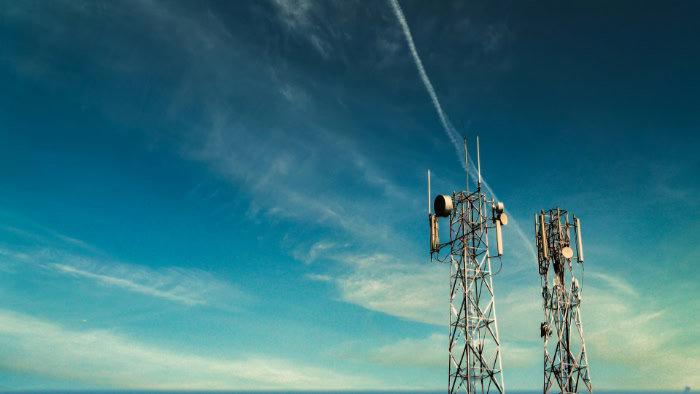 Cellular communication towers under clear blue sky