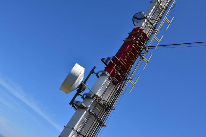 Cellular tower with antennas against blue sky