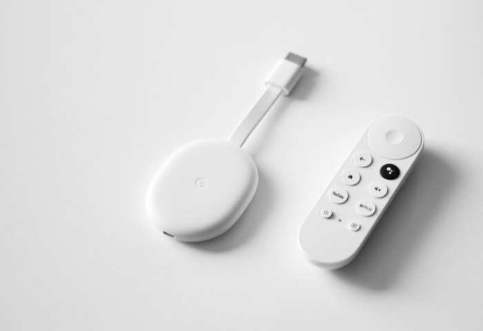 Chromecast device and remote control on white background