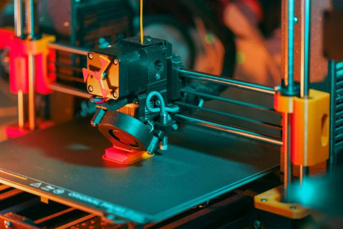 Close up of 3D printer nozzle extruding filament