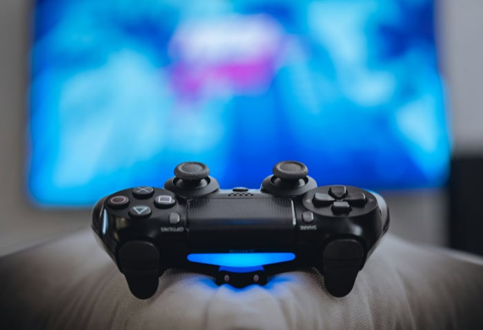 Close up of a black PlayStation controller with blurred background